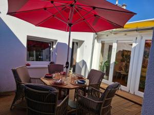 a wooden table with a red umbrella on a deck at Diana's Stube in Krefeld