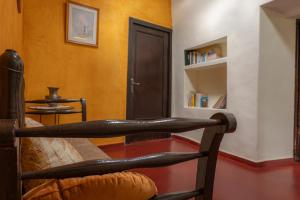 uma cadeira de madeira num quarto com uma estante de livros em Masia en plena naturaleza y tranquilidad em San Quintín de Mediona