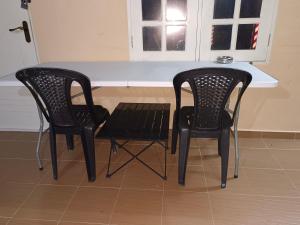 two black chairs and a table in a kitchen at ROOMSTAY NIMAZA Bilik 1 in Marang