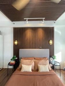 um quarto com uma cama grande e duas mesas em Muji-Inspired hōme-tél in the heart of Makati em Manila