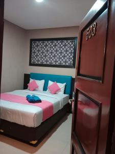 Un pat sau paturi într-o cameră la Erin Int Hotel