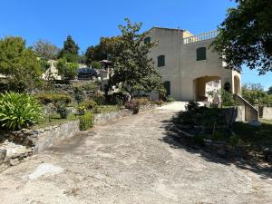 un vialetto che conduce a una casa con giardino di Corse CERVIONE T2 a Cervione