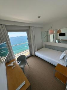 a hotel room with a bed and a desk and a window at Hotel Miramare - Adults Only in Trieste