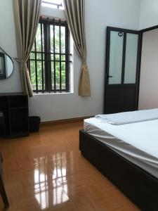 Un dormitorio con una cama y una ventana grande en Hải Lê Tam Coc Happy Homestay, en Ninh Binh