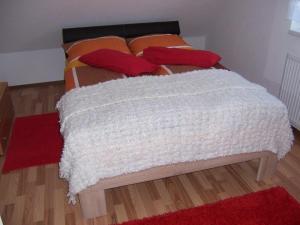 Una cama con una manta blanca encima. en Ferienhaus Waldfee, en Reutin