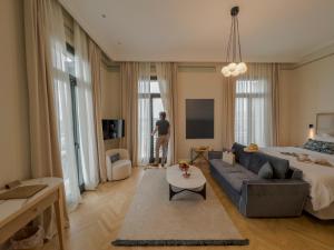 a man is standing in a living room with a couch at EPICURE SUITES in Kavála