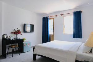 een slaapkamer met een bed en een raam met blauwe gordijnen bij Nicecy Hotel - Yersin Street in Ho Chi Minh-stad