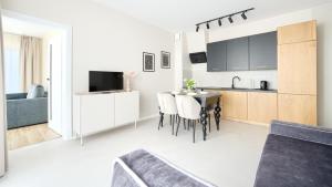 隱海市的住宿－Apartamenty Sun & Snow Słoneczne，厨房以及带桌子和沙发的客厅。