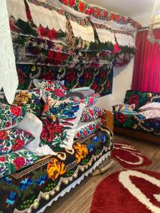 a living room filled with colorful pillows and a couch at Trai bun in Maramures in Fereşti