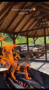 a fire burns in front of a picnic shelter at Коло Гір in Kolochava