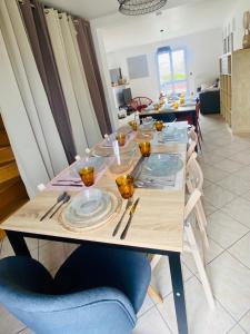 a table with plates on it in a living room at Maison calme et fonctionnelle business sportifs et familles PAS DE FETE in Corbeil-Essonnes