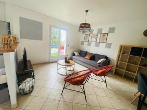 a living room with a couch and a table at Maison calme et fonctionnelle business sportifs et familles PAS DE FETE in Corbeil-Essonnes