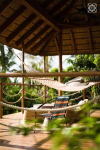 un patio con hamaca y una silla en una terraza en Zuri Zanzibar, en Kendwa