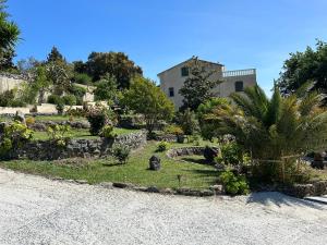 un jardin en face d'une maison avec un bâtiment dans l'établissement Corse CERVIONE T2, à Cervione