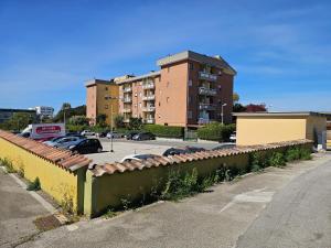 una valla frente a un estacionamiento con un edificio en Cristian House, en Pomezia