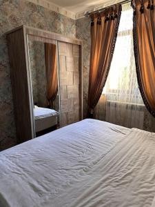 Un dormitorio con una cama grande y un espejo. en Apartment in the city center, en Samarkand