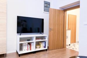 een woonkamer met een televisie op een wit entertainmentcentrum bij Aumetz square apartment in Idrija