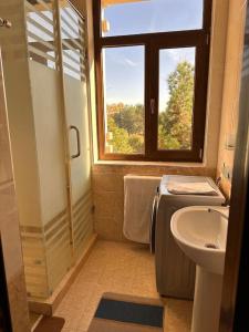Un baño con lavabo, inodoro y ventana. en Apartment in the city center, en Samarkand