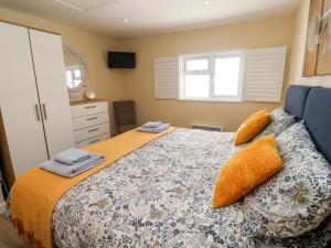 a bedroom with a bed with orange sheets and a window at Chy-An-Oula in Falmouth