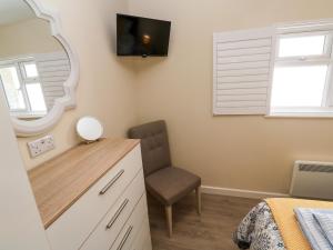 a bedroom with a mirror and a chair at Chy-An-Oula in Falmouth