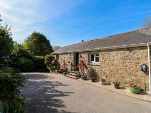 a stone house with potted plants in front of it at Chy-An-Oula in Falmouth