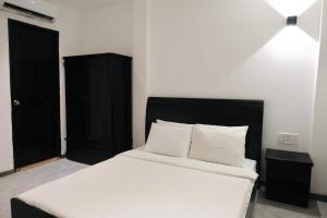 a bedroom with a bed and a black cabinet at Nicecy Hotel - Yersin Street in Ho Chi Minh City