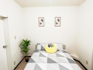 a bedroom with a bed with a yellow pillow on it at 池袋2分 3Rooms 6人可 in Tokyo