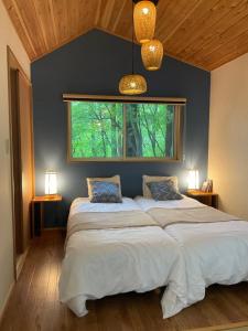 a bedroom with two beds and a window at Retreat Camp Mahoroba in Fujikawaguchiko
