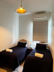 a bedroom with two beds and a lamp and a window at Grand Old Crow Hotel in Crows Nest +5 photos