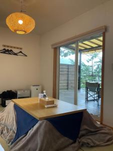 Cette chambre dispose d'une table en bois et offre une vue sur le patio. dans l'établissement Retreat Camp Mahoroba, à Fujikawaguchiko