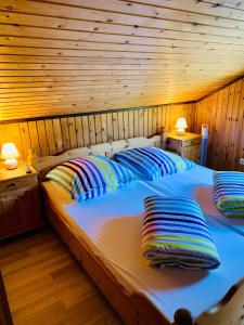 a bed in a wooden room with two pillows on it at Komfort-Ferienhaus - Extertal Ferienpark - Entspannung, Natur, Wald, Familie #51 in Extertal