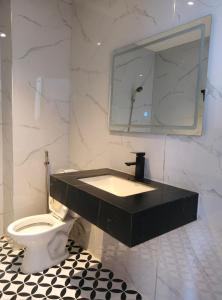 a bathroom with a black sink and a toilet at Nicecy Hotel - Yersin Street in Ho Chi Minh City
