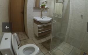 a bathroom with a toilet and a sink and a shower at Chalé no Camping Carrion próximo a Tomorrowland in Itu