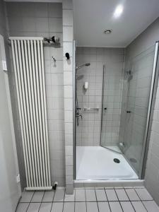 a shower with a glass door in a bathroom at Haus Villigst - Tagungsstätte der EKvW in Schwerte