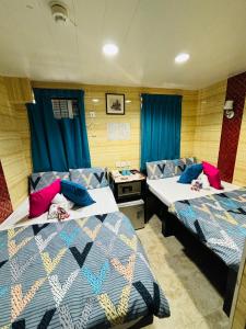 two beds in a room with blue curtains at Philippine Hostel in Hong Kong