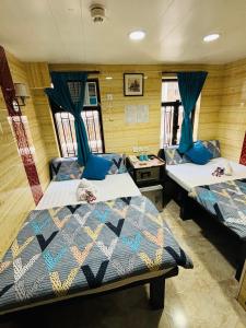 2 camas en una habitación con cortinas azules en Philippine Hostel en Hong Kong