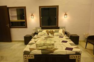 Un dormitorio con una cama grande con almohadas. en Colonel's Cottage, en Jaipur
