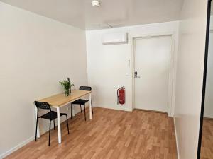 a room with a table and chairs and a door at Brufjell Hostel & Parking in Flekkefjord