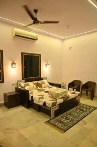 1 dormitorio con 1 cama y ventilador de techo en Colonel's Cottage, en Jaipur