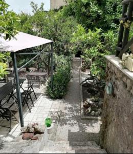 un patio esterno con tavolo, sedie e alberi di Il giardino dei sogni a Gaeta