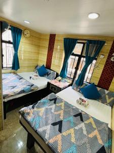 2 camas en una habitación con cortinas azules en Philippine Hostel, en Hong Kong