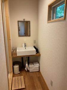 La salle de bains est pourvue d'un lavabo et d'un miroir. dans l'établissement Retreat Camp Mahoroba, à Fujikawaguchiko