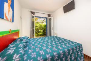 a bedroom with a blue bed and a window at Casa Arts 50 in Campos