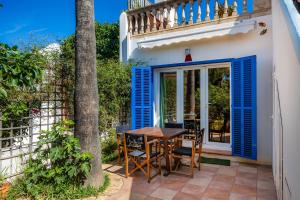 a patio with blue shutters and a table and chairs at Casa Arts 50 in Campos