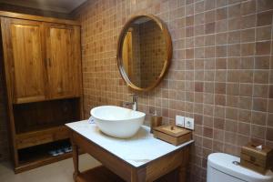 a bathroom with a bowl sink and a mirror at De Umah Bali Eco Tradi Home in Bangli