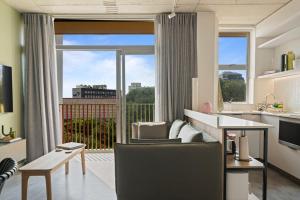 een keuken en een woonkamer met een groot raam bij Six On N Apartments - Managed by Propr in Kaapstad