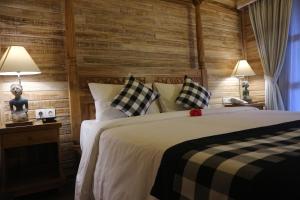 1 dormitorio con 1 cama grande y 2 lámparas en De Umah Bali Eco Tradi Home en Bangli