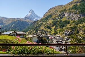 a view of a mountain from a balcony with flowers at Hotel Alpenroyal in Zermatt