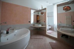 y un baño grande con 2 lavabos, bañera y espejo. en La casa dei girasoli wifi e relax en Génova