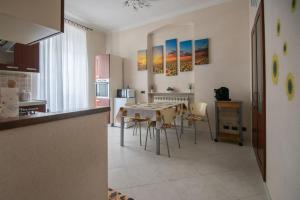 una cucina e una sala da pranzo con tavolo e sedie di La casa dei girasoli wifi e relax a Genova